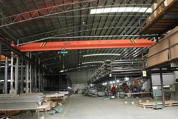 Orange overhead crane with black and yellow safety markings.