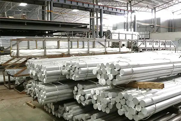 Stacks of silver-colored aluminum alloy rods, neatly bundled and arranged in a warehouse setting.